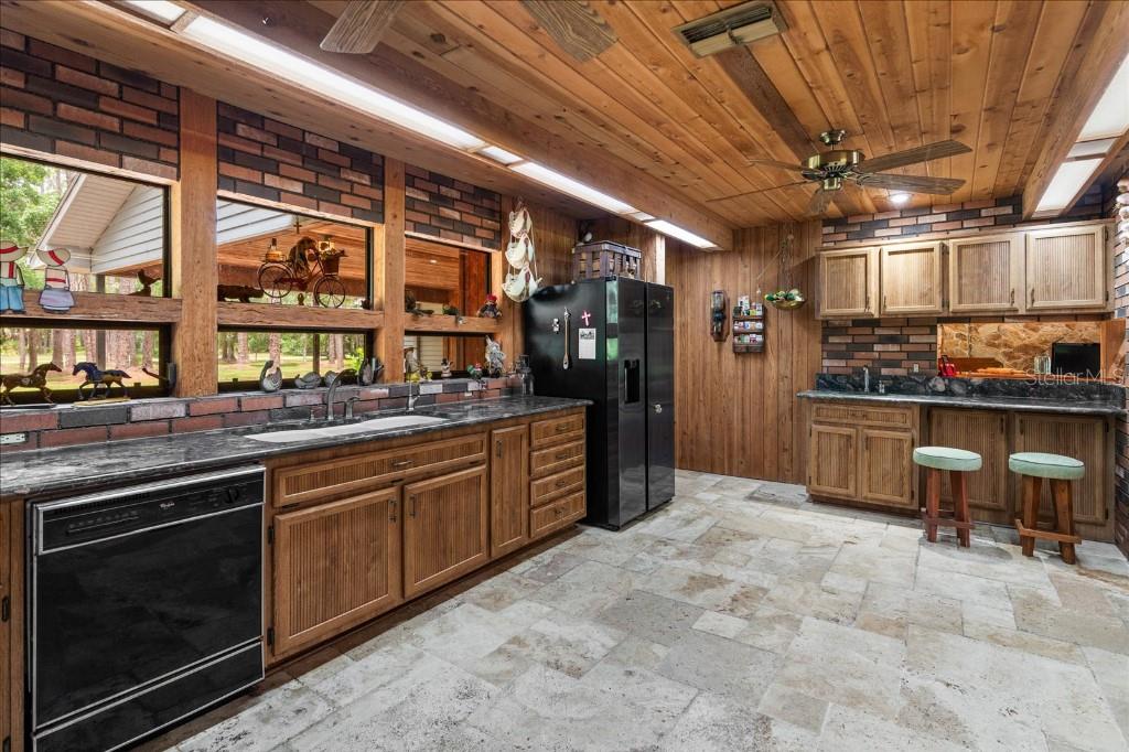 935 Ranch Road Tarpon Springs, FL 34688 - Photo 18 of 40 a kitchen with stainless steel appliances granite countertop a stove a sink and a refrigerator