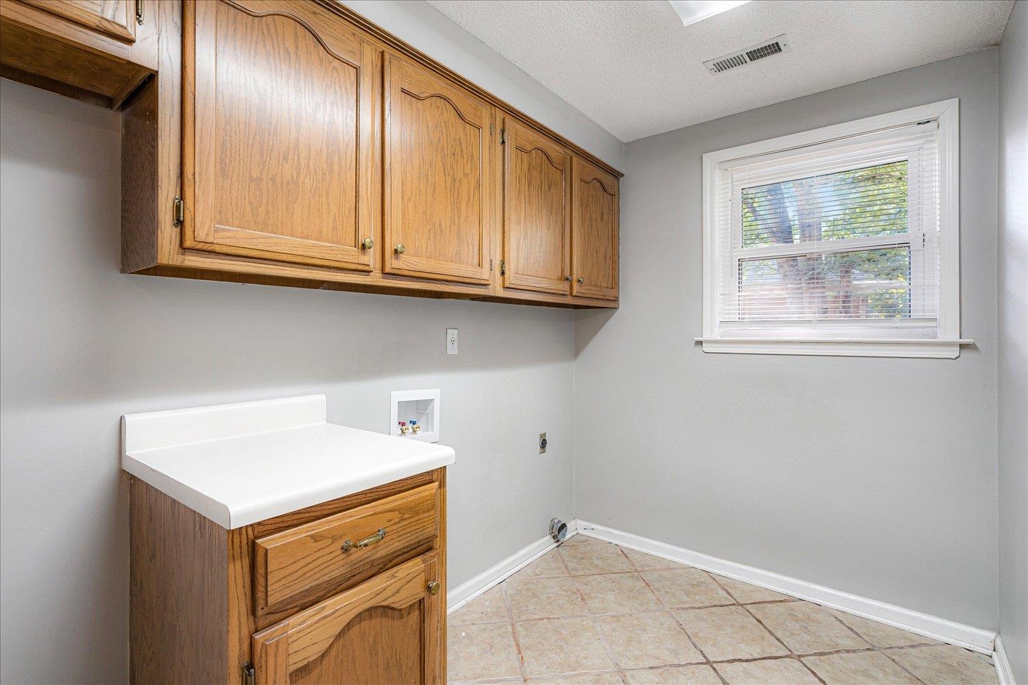 910 Sugar Cove Collierville, TN 38017 - Photo 16 of 32 Laundry area with a textured ceiling, light tile patterned floors, washer hookup, cabinet space, and hookup for an electric dryer