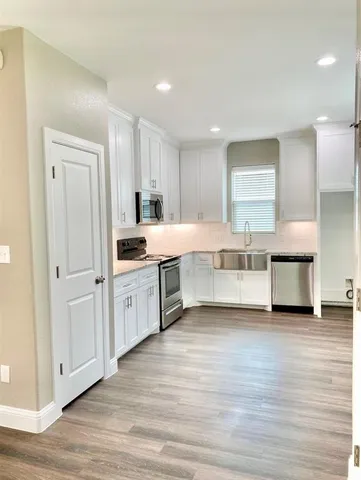 a large white kitchen with a white wooden cabinets