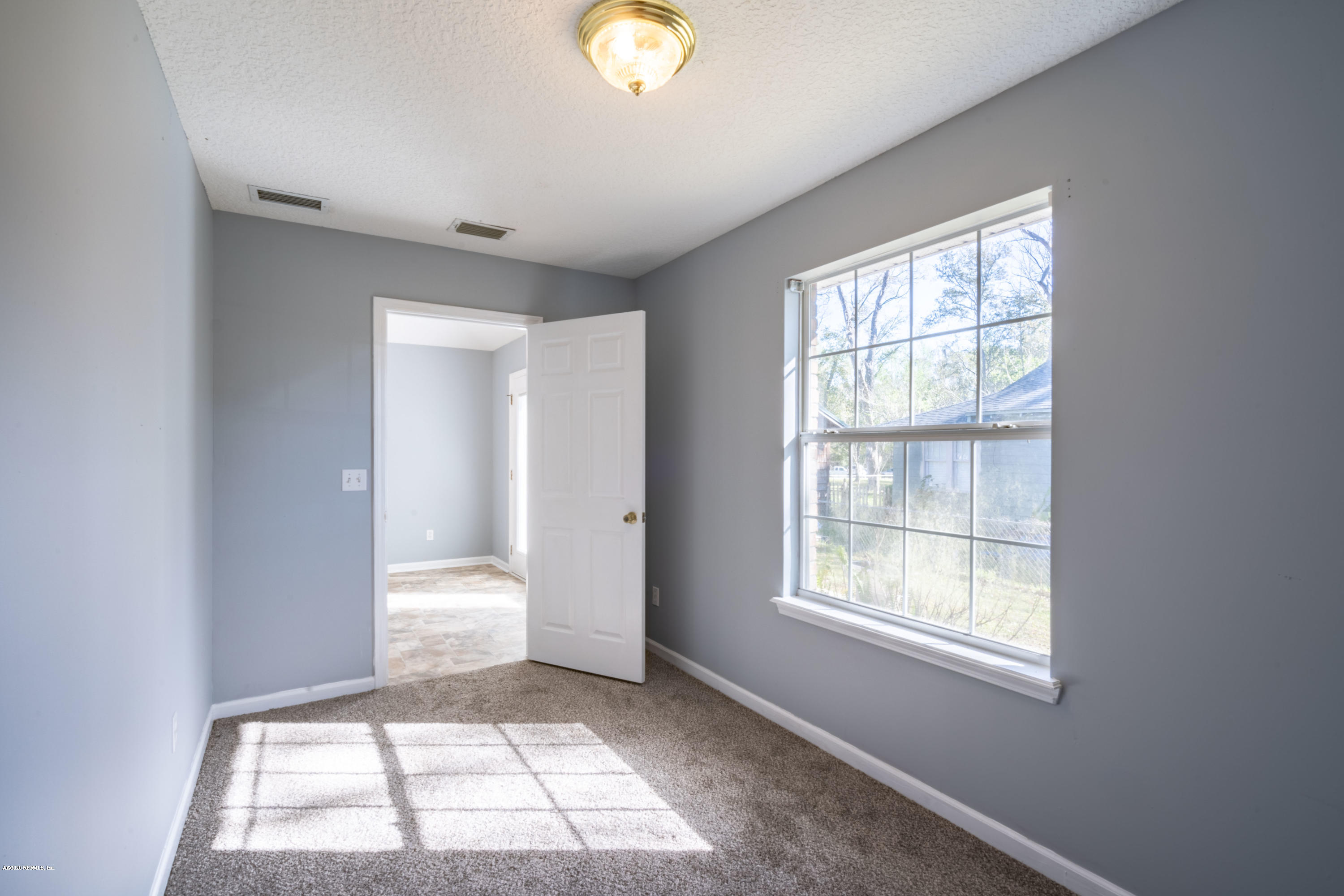 1175 Cahoon Road South Jacksonville, FL 32221 - Photo 7 of 16 wooden floor in an empty room with a window