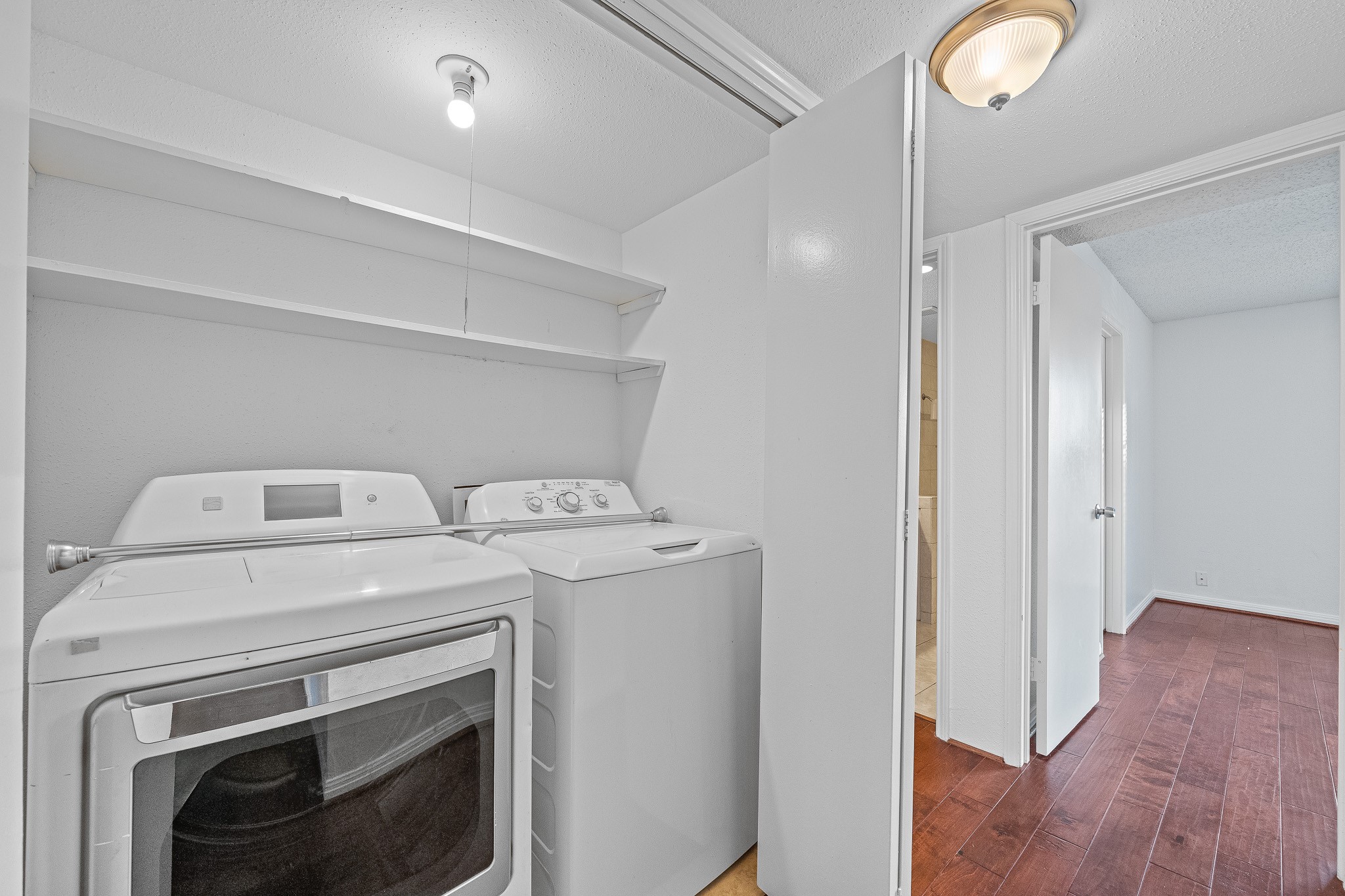 12100 Overbrook Lane, Unit 17D Houston, TX 77077 - Photo 11 of 22 a view of washer and dryer with wooden floor