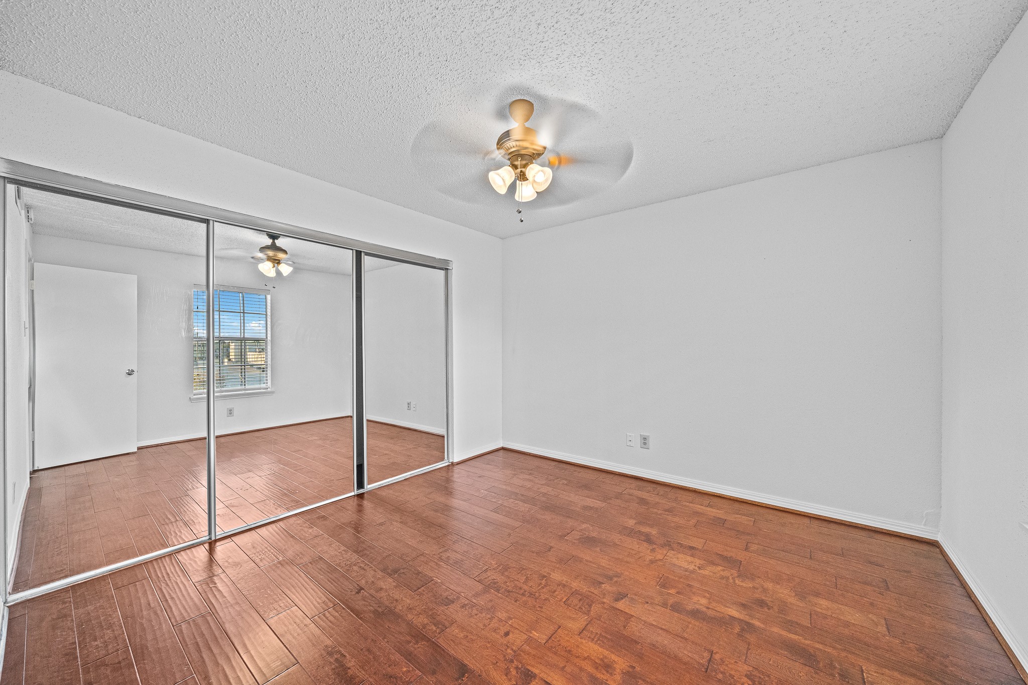 12100 Overbrook Lane, Unit 17D Houston, TX 77077 - Photo 16 of 22 wooden floor in an empty room with a window