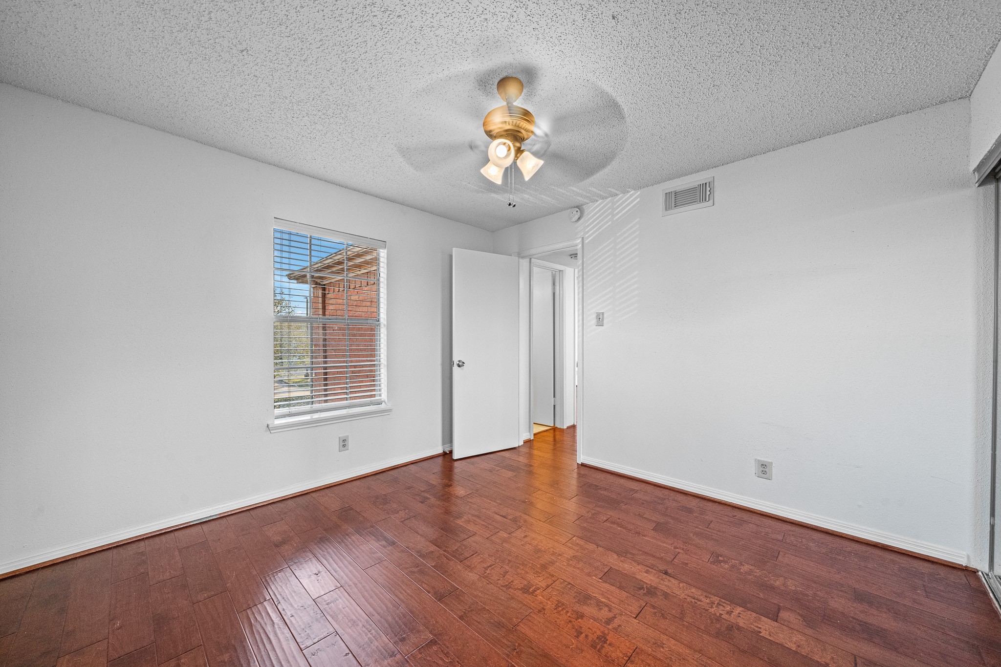 12100 Overbrook Lane, Unit 17D Houston, TX 77077 - Photo 17 of 22 wooden floor in an empty room with a window