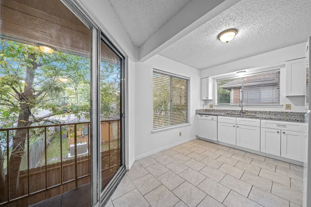 a large white room with a large window and kitchen view