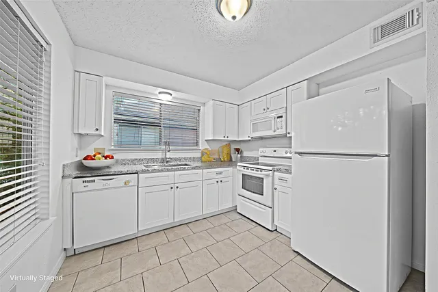 a kitchen with white cabinets and white appliances