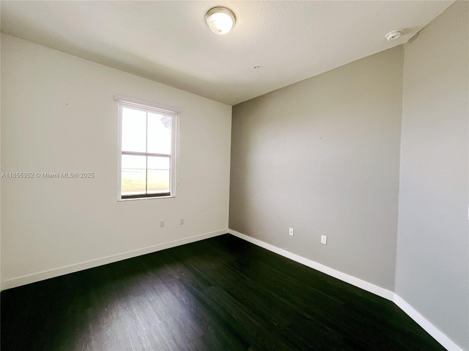 15650 Southwest 136th Street, Unit 218 Miami, FL 33196 - Photo 11 of 25 an empty room with wooden floor and windows