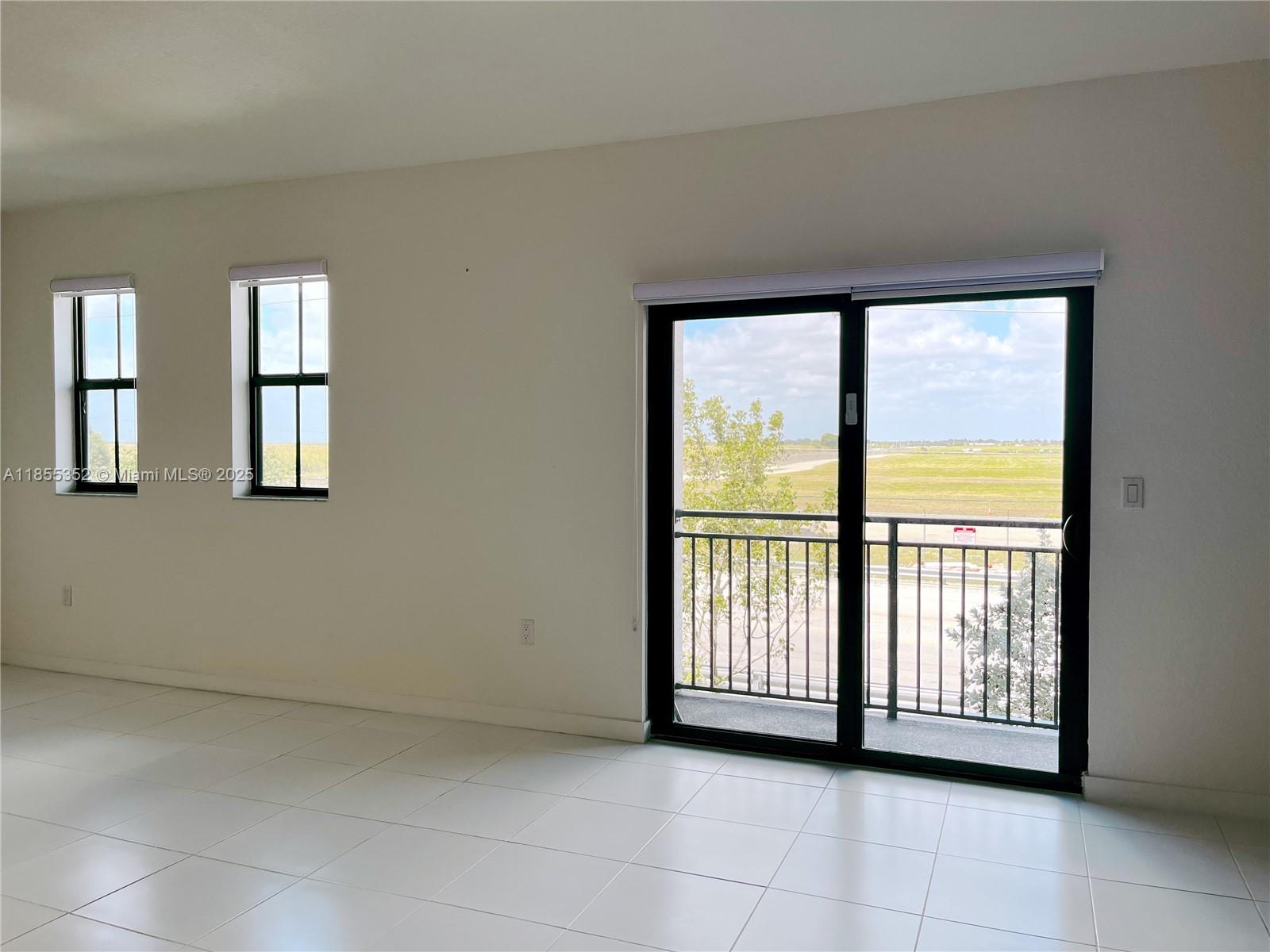 15650 Southwest 136th Street, Unit 218 Miami, FL 33196 - Photo 19 of 25 a view of a big room with windows and chandelier fan