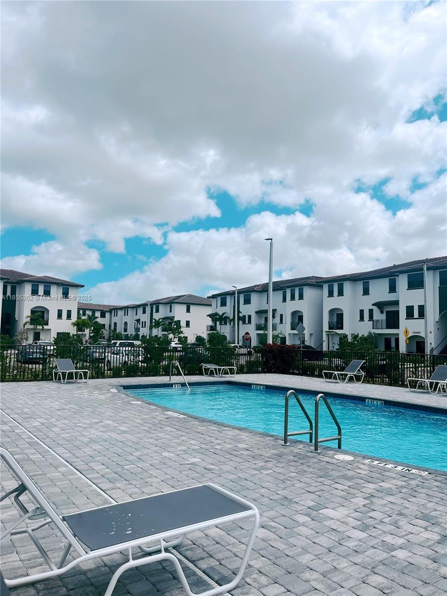 15650 Southwest 136th Street, Unit 218 Miami, FL 33196 - Photo 24 of 25 a house view with a swimming pool and garden space