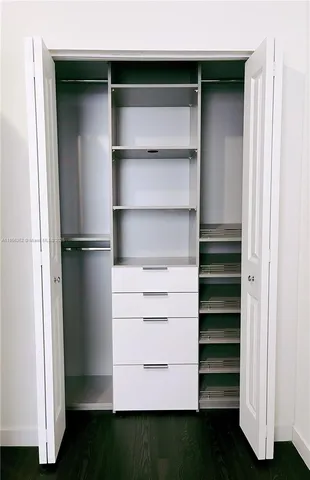 a view of walk in closet with empty racks