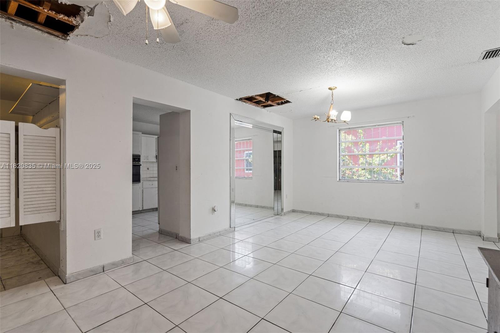2920 Southwest 37th Court Miami, FL 33134 - Photo 23 of 48 an empty room with chandelier fan and windows