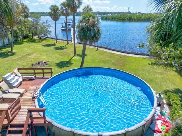 an aerial view of a house with swimming pool and garden