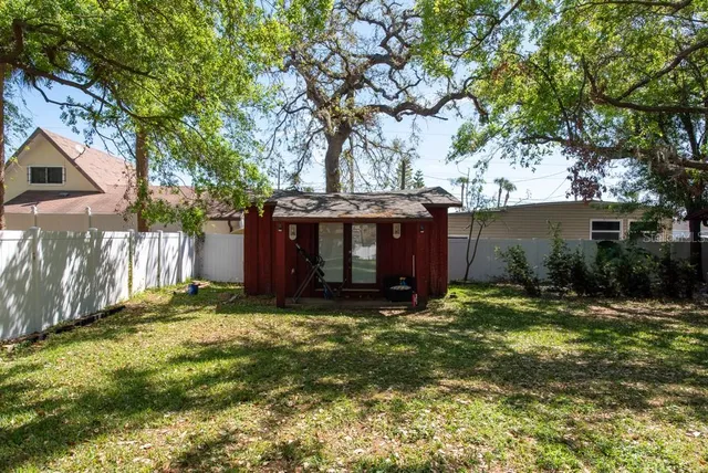 a view of swimming pool with a yard and palm trees