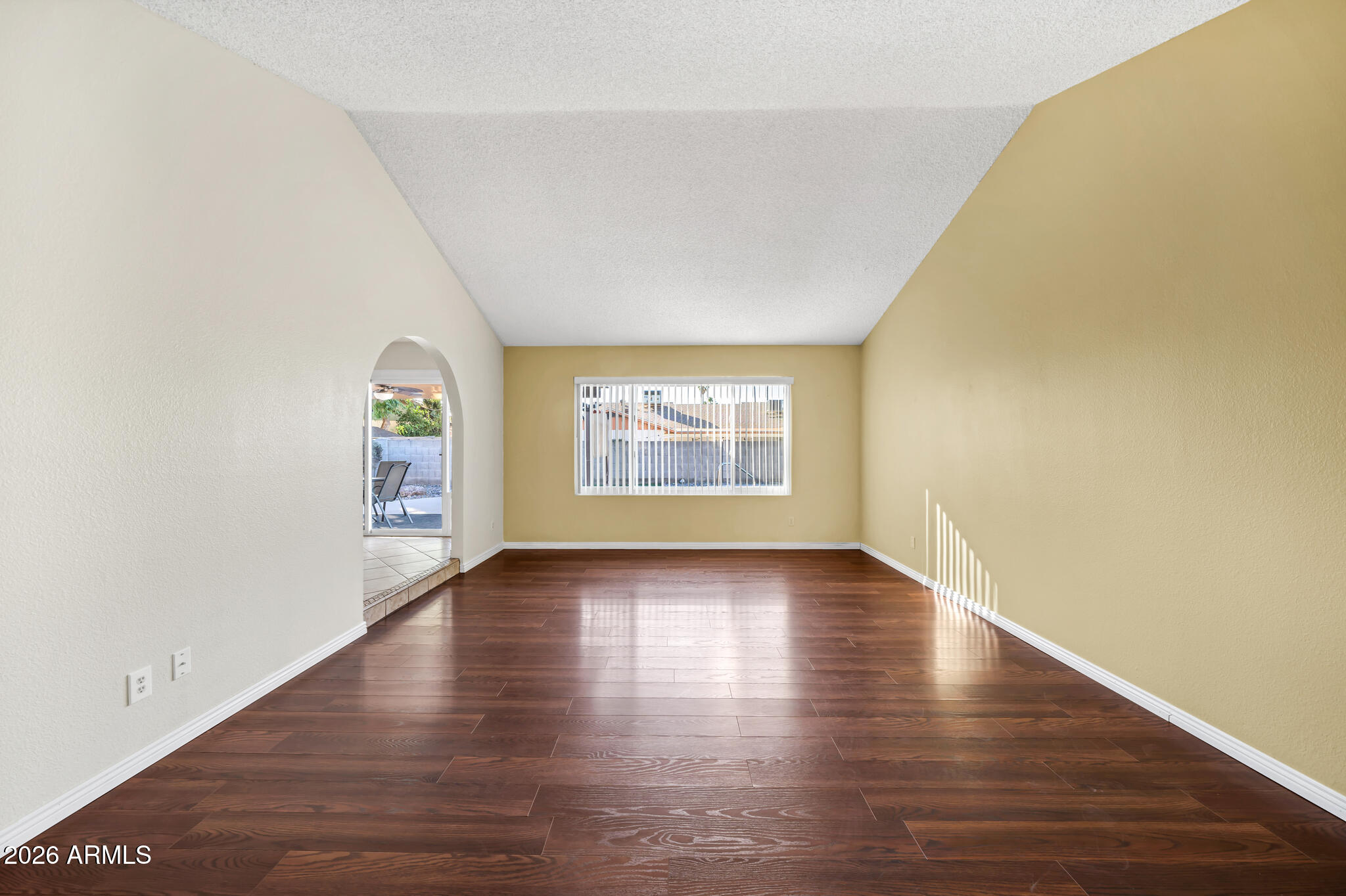 3033 West Kathleen Road Phoenix, AZ 85053 - Photo 10 of 42 a view of an empty room with wooden floor and a window