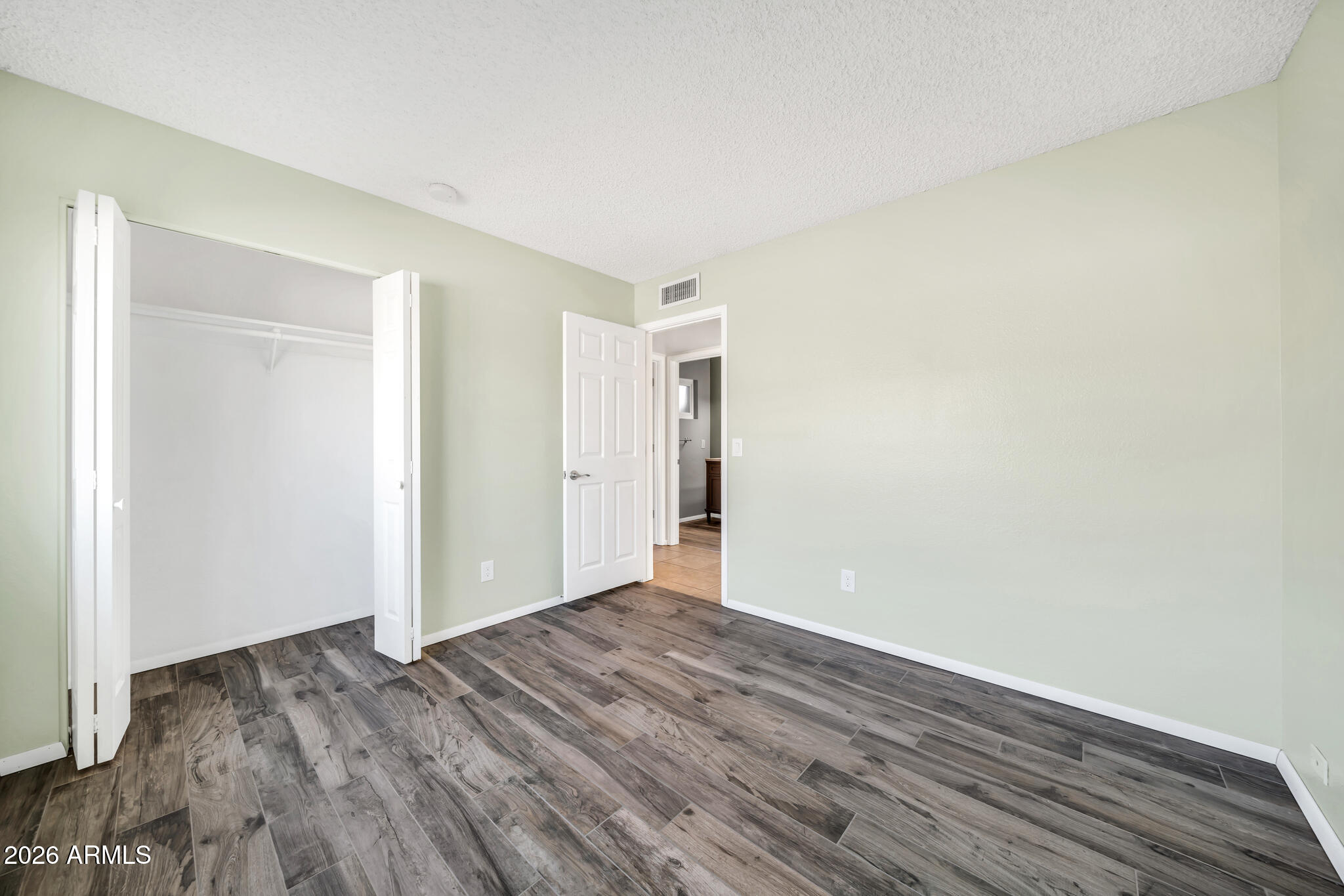3033 West Kathleen Road Phoenix, AZ 85053 - Photo 21 of 42 a view of an empty room with wooden floor