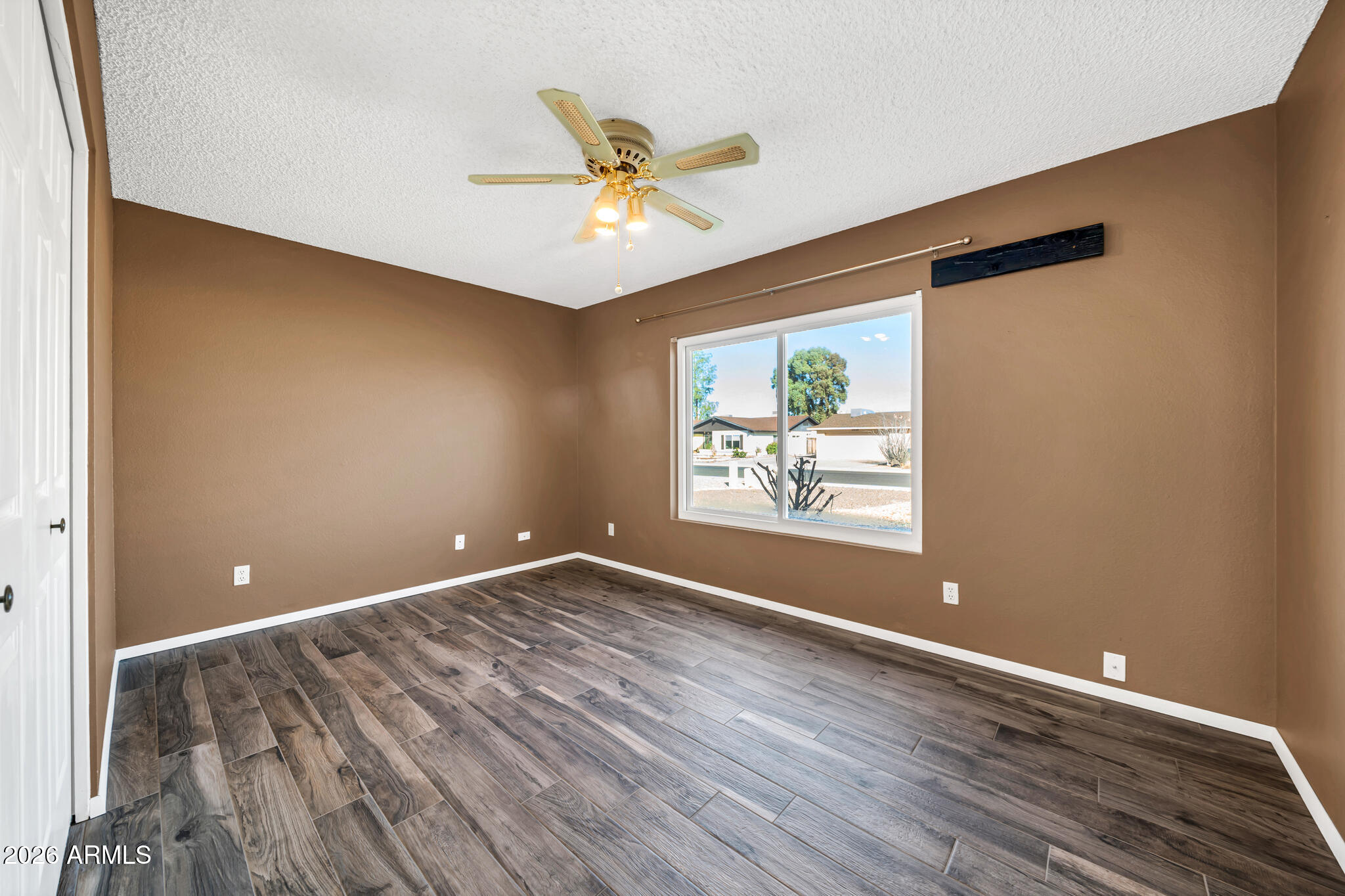 3033 West Kathleen Road Phoenix, AZ 85053 - Photo 23 of 42 a view of an empty room with wooden floor and a window