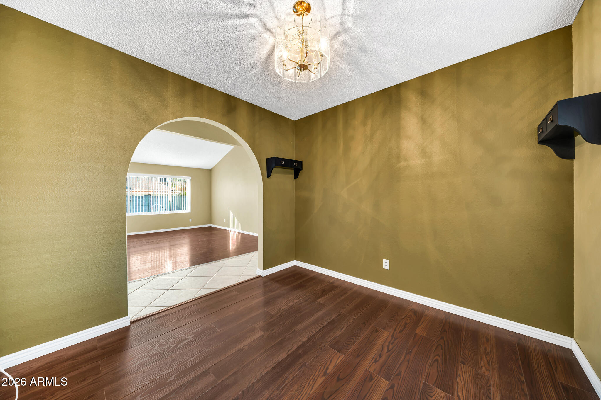 3033 West Kathleen Road Phoenix, AZ 85053 - Photo 27 of 42 a view of an empty room with window and wooden floor