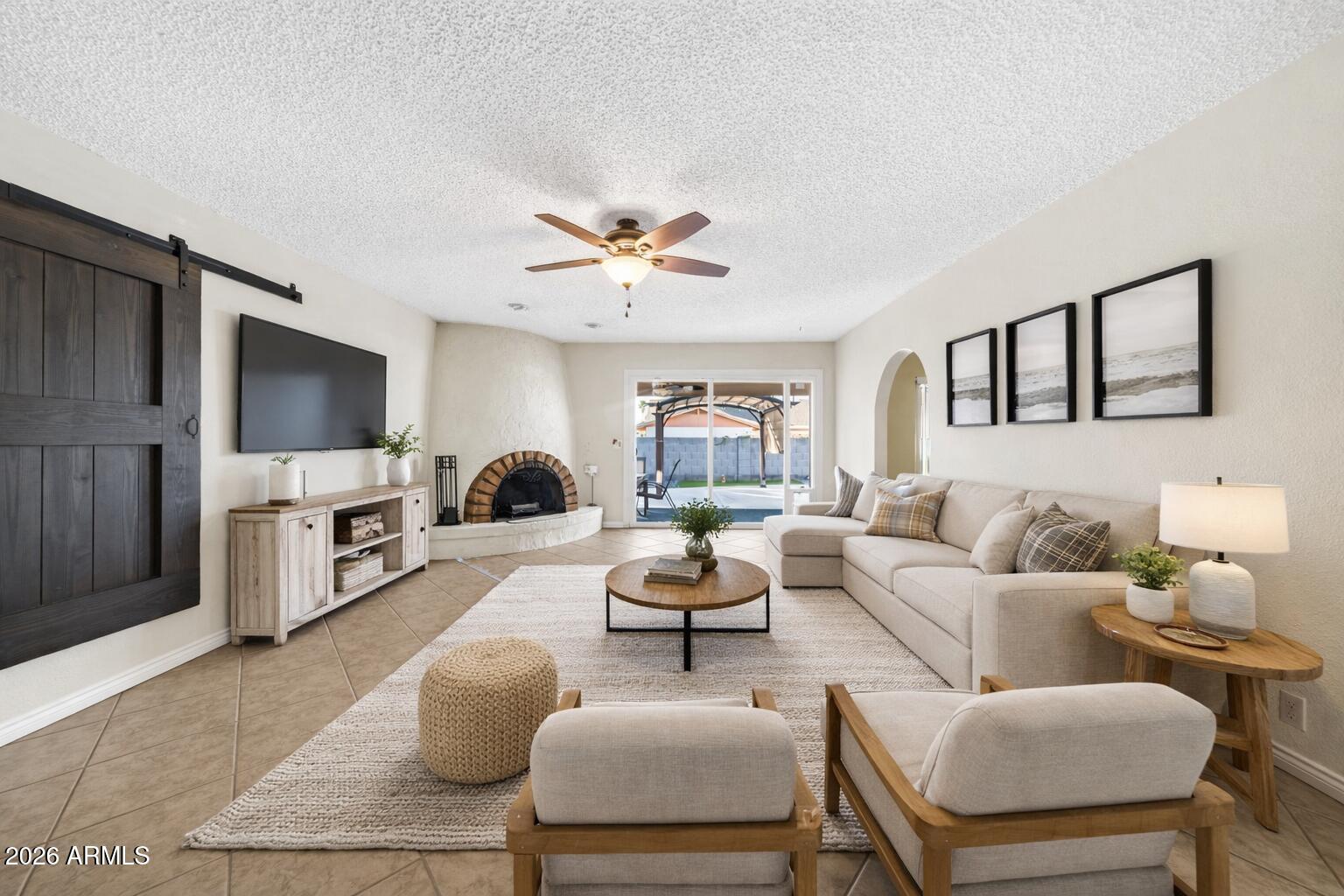 3033 West Kathleen Road Phoenix, AZ 85053 - Photo 5 of 42 a living room with furniture a chandelier and a flat screen tv