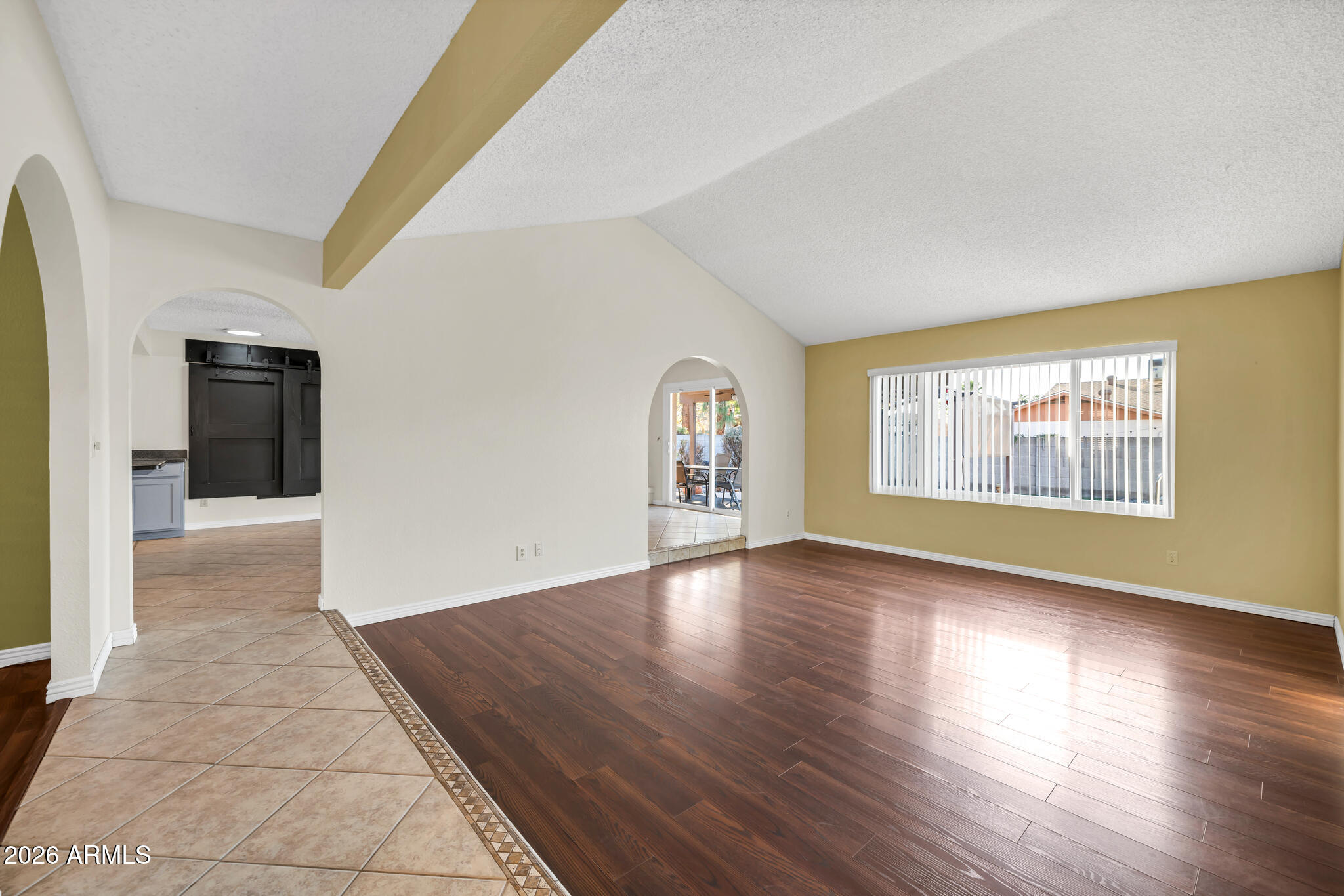 3033 West Kathleen Road Phoenix, AZ 85053 - Photo 9 of 42 an empty room with wooden floor and windows
