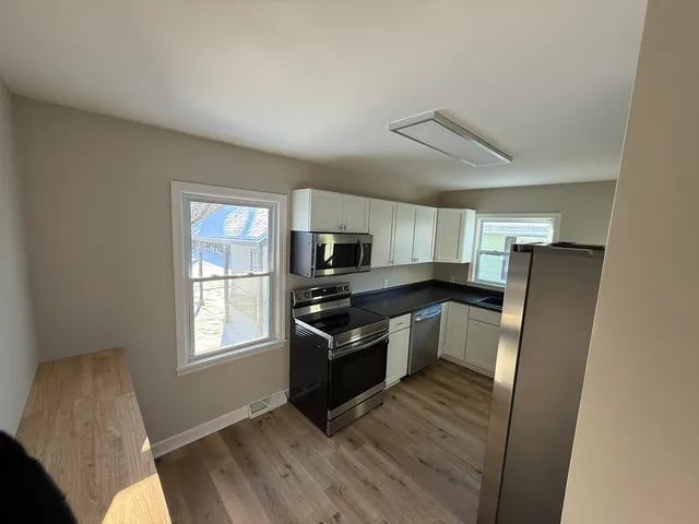a kitchen with stainless steel appliances granite countertop a refrigerator and a stove top oven