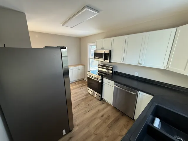 a kitchen with kitchen island a counter top space appliances and cabinets