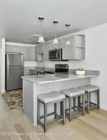 a kitchen with kitchen island a stove a refrigerator and a sink