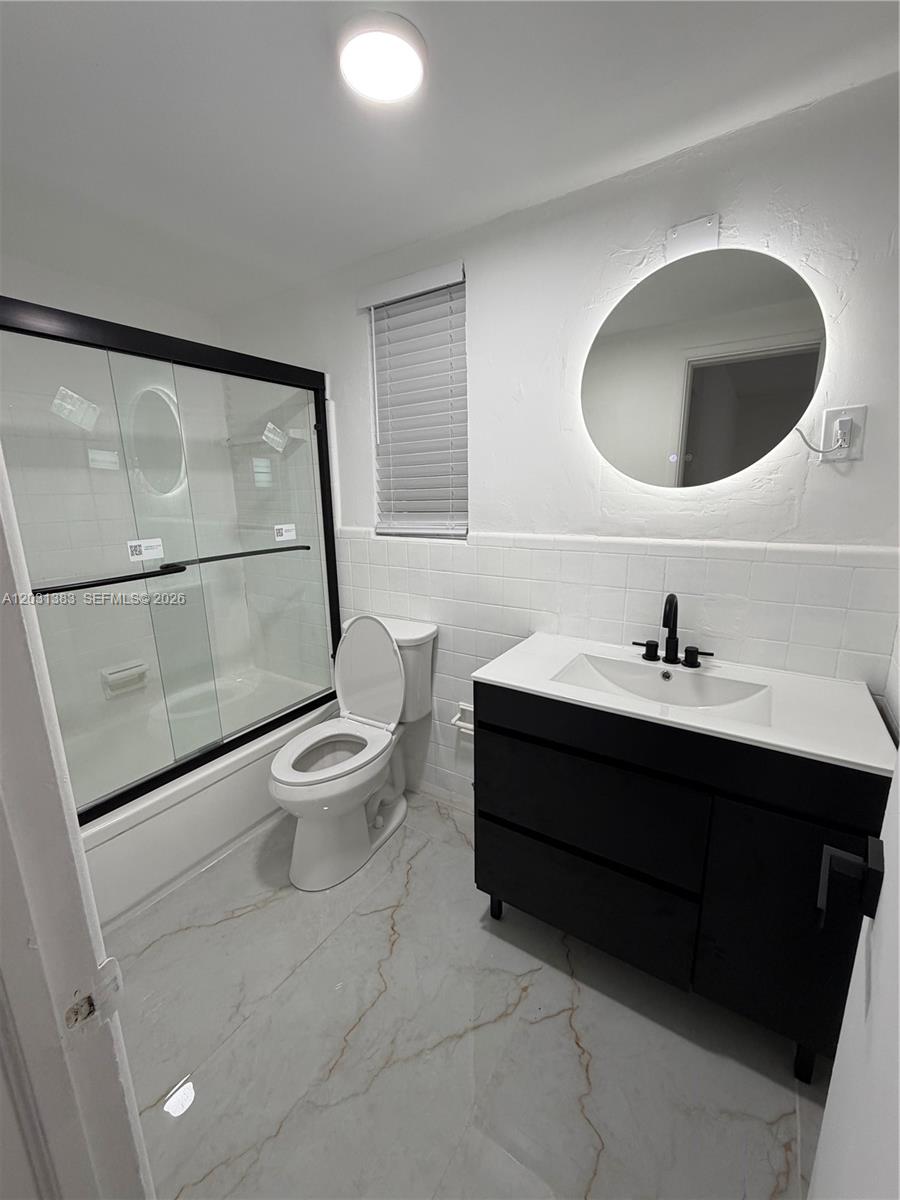 324 Surfside Boulevard, Unit 7 Surfside, FL 33154 - Photo 1 of 8 a bathroom with a toilet sink and mirror