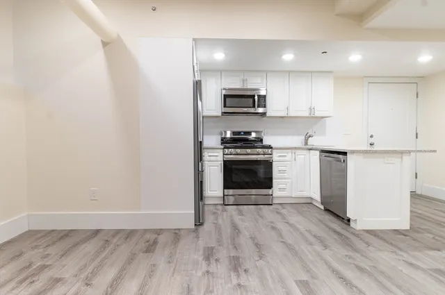 a kitchen with stainless steel appliances a stove top oven a sink and a refrigerator