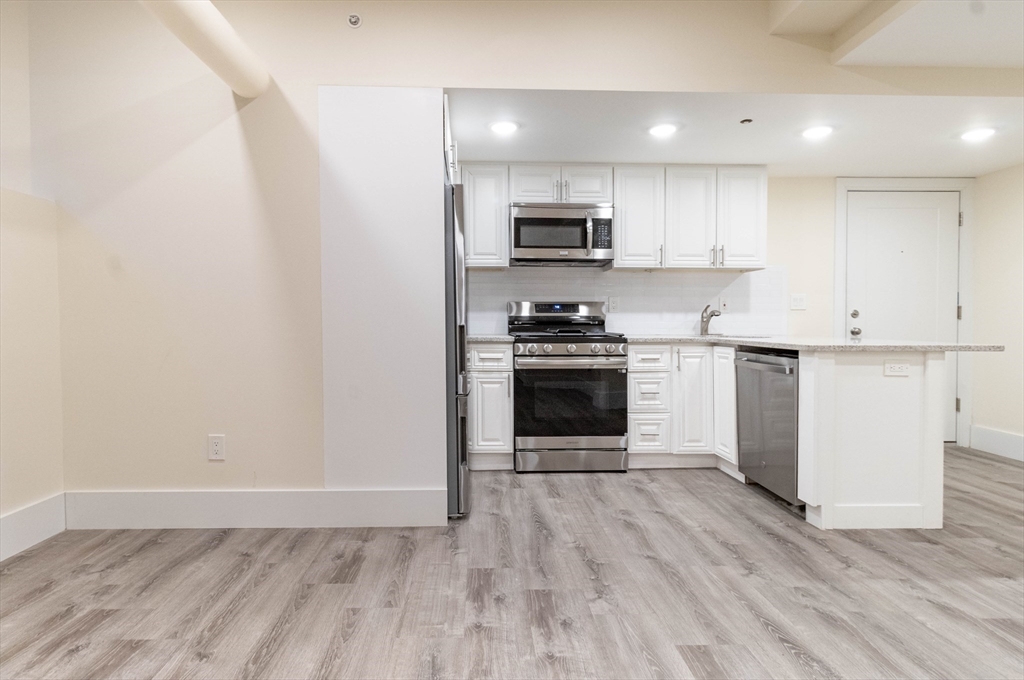 25 Peterborough Street, Unit 31 Boston, MA 02215 - Photo 5 of 14 a kitchen with stainless steel appliances a stove top oven a sink and a refrigerator