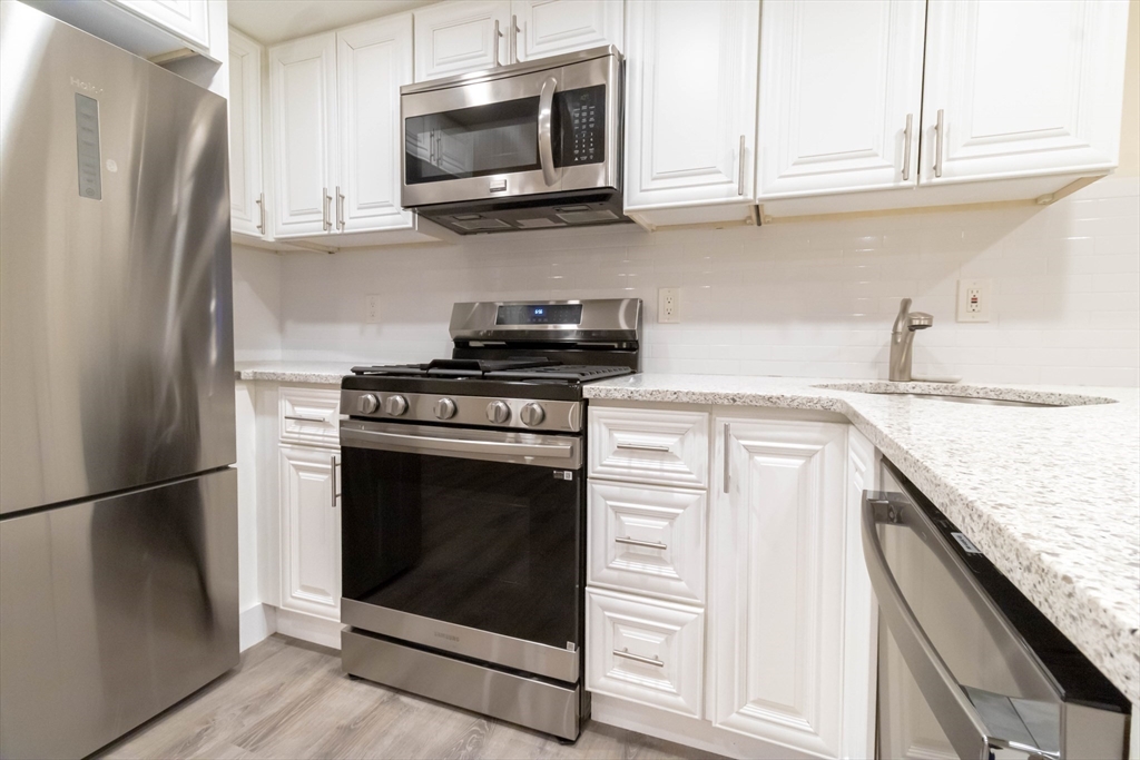 25 Peterborough Street, Unit 31 Boston, MA 02215 - Photo 6 of 14 a kitchen with stainless steel appliances granite countertop a stove microwave and refrigerator
