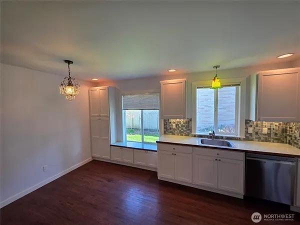 a kitchen with a refrigerator stove and wooden cabinets