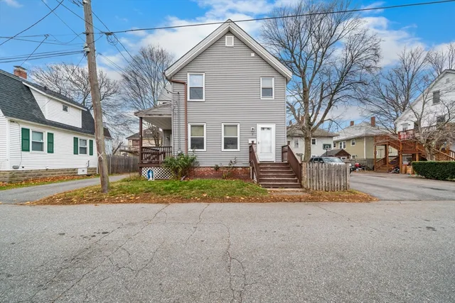 a view of a house with a yard and large tree