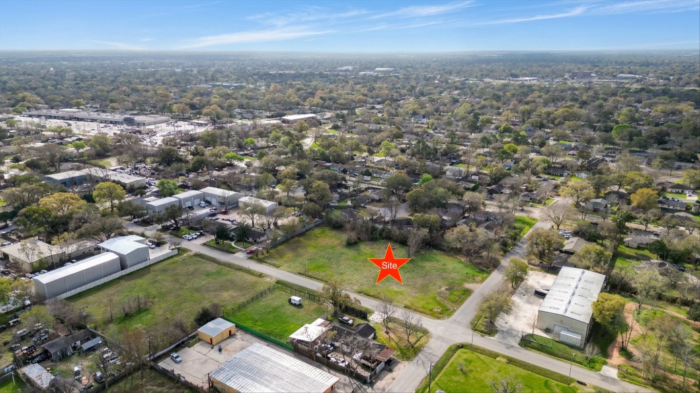 an aerial view of residential houses with outdoor space and trees