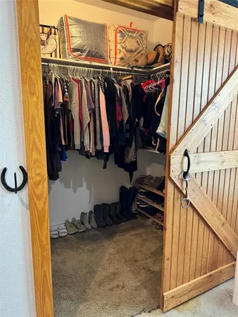 a view of walk in closet with clothes and shoes