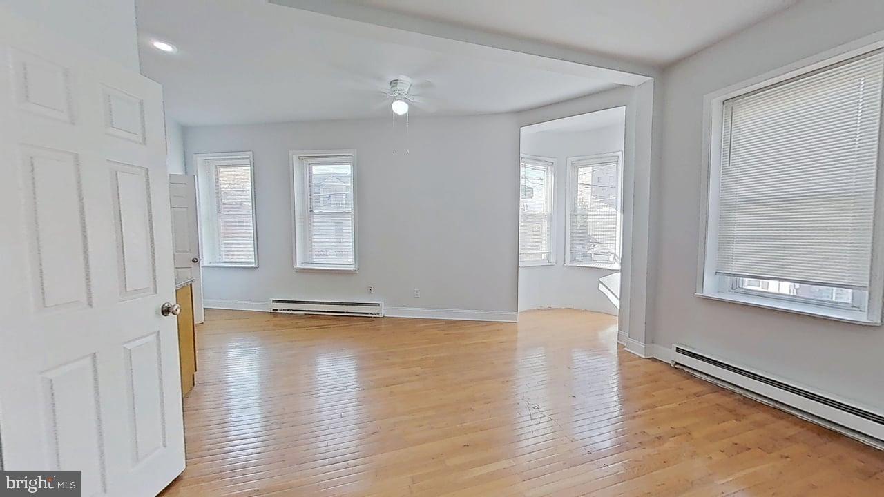 1234-40 Rising Sun Avenue, Unit C Philadelphia, PA 19140 - Photo 3 of 10 an empty room with wooden floor and windows