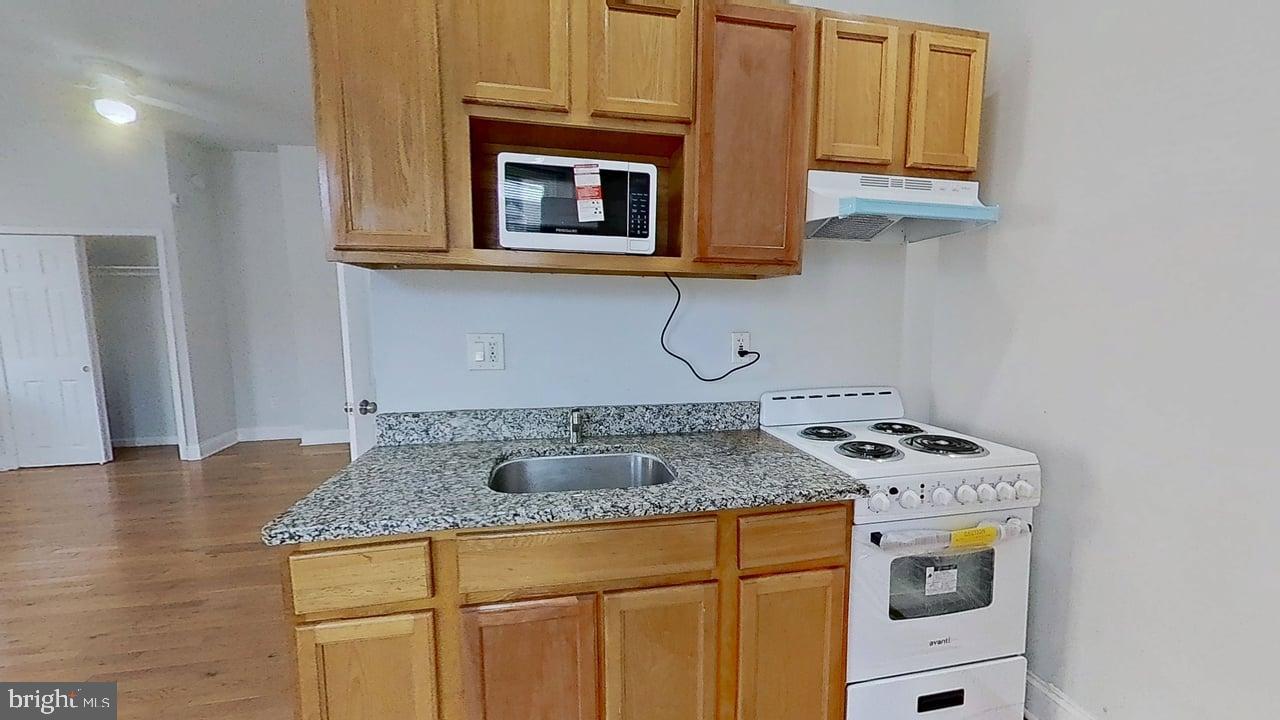 1234-40 Rising Sun Avenue, Unit C Philadelphia, PA 19140 - Photo 7 of 10 a kitchen with granite countertop a sink a stove and cabinets