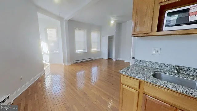 a hallway with granite countertop wooden cabinets a sink and dishwasher