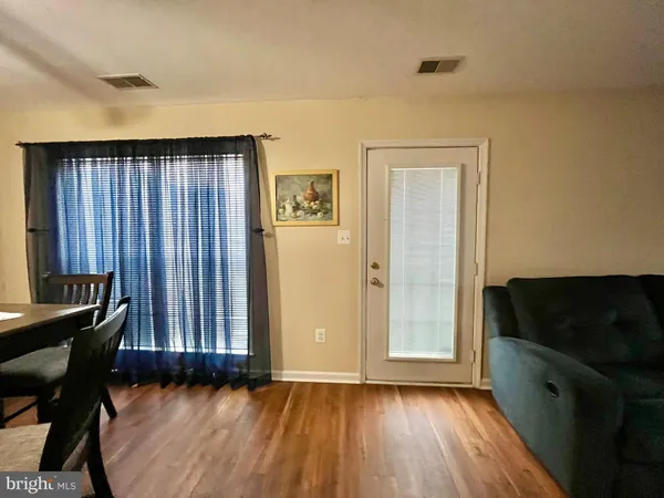 a view of a room with wooden floor and furniture
