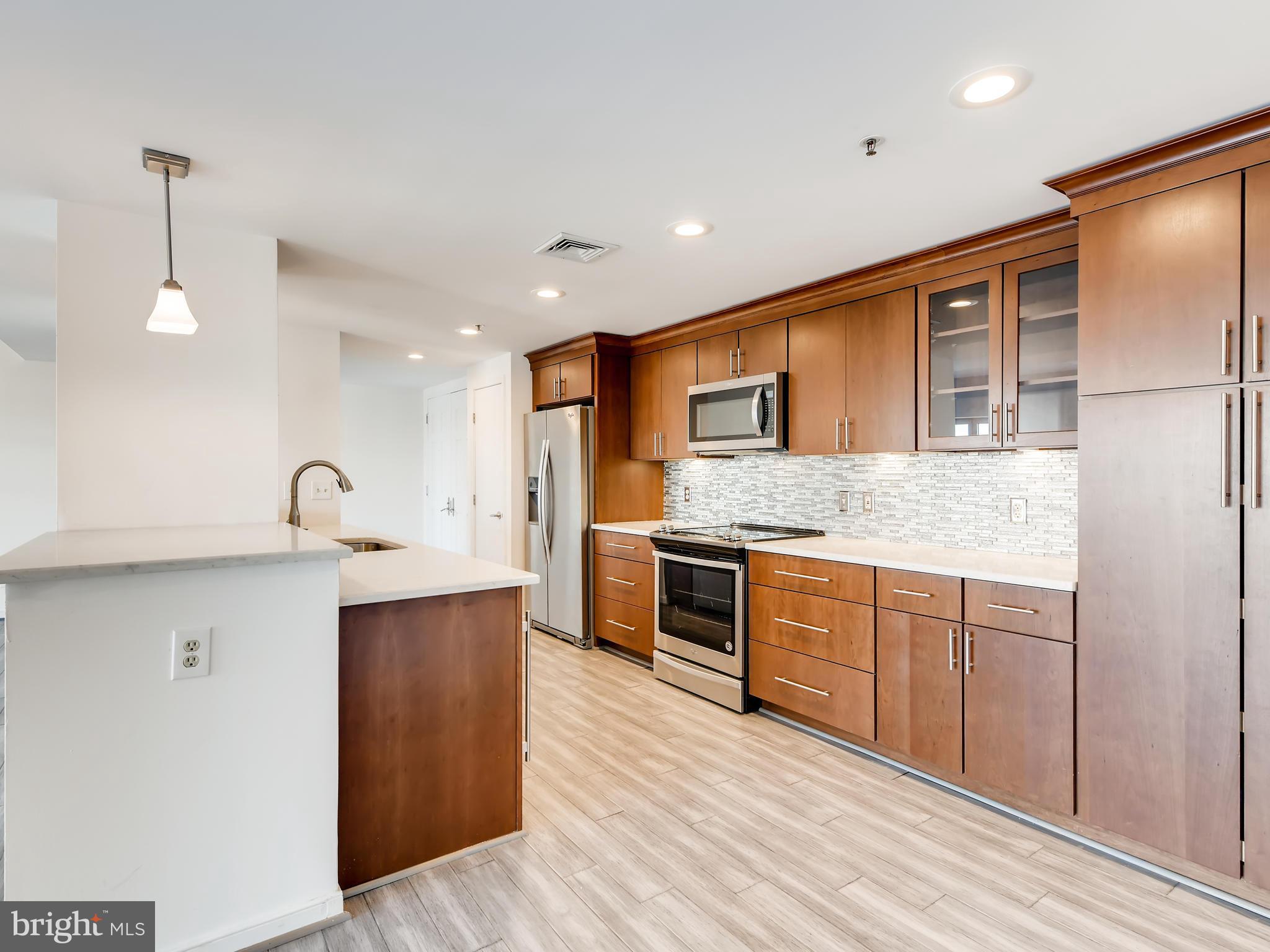 a large kitchen with stainless steel appliances granite countertop a stove and a sink