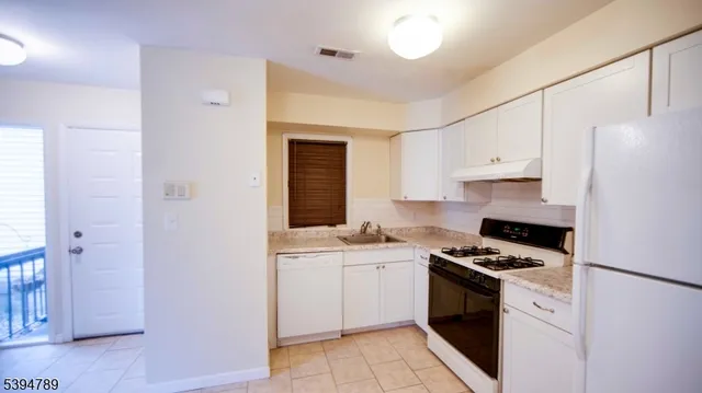 a kitchen with cabinets appliances and a window