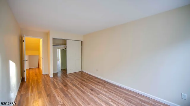 a view of a room with wooden floor and a bathroom