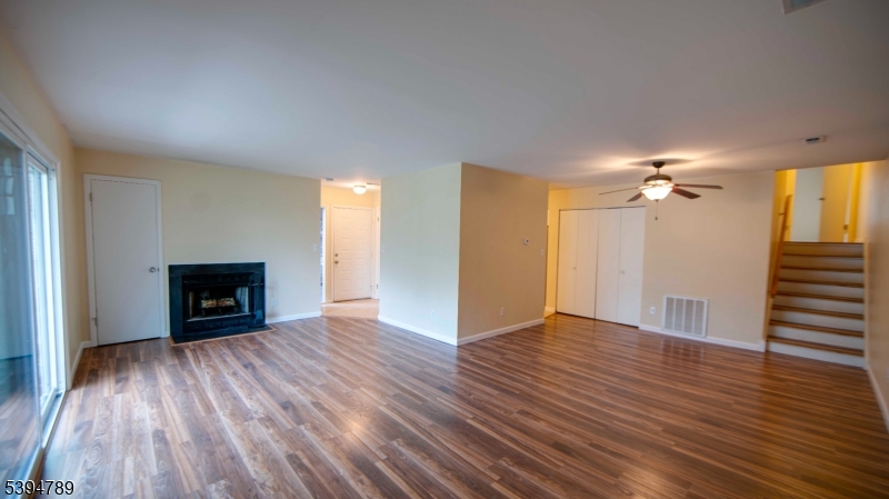 22 Sam Bonnell Drive, Unit 22 Clinton, NJ 08809 - Photo 5 of 16 an empty room with wooden floor fireplace and windows