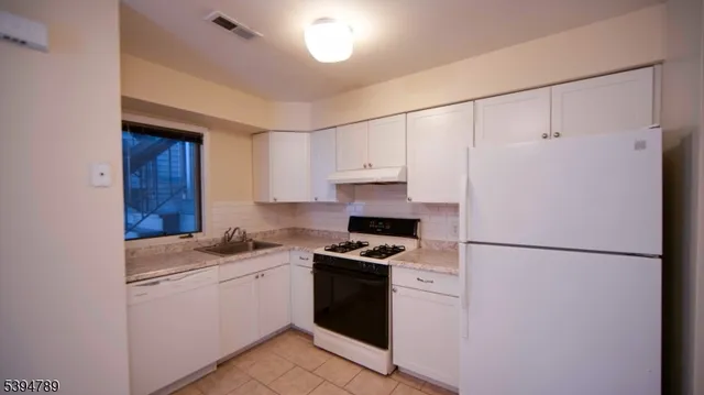 a kitchen with a refrigerator and a stove top oven