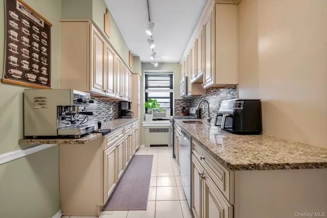 a kitchen with stainless steel appliances granite countertop a sink stove and cabinets