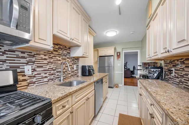 a kitchen with stainless steel appliances granite countertop a sink stove and cabinets