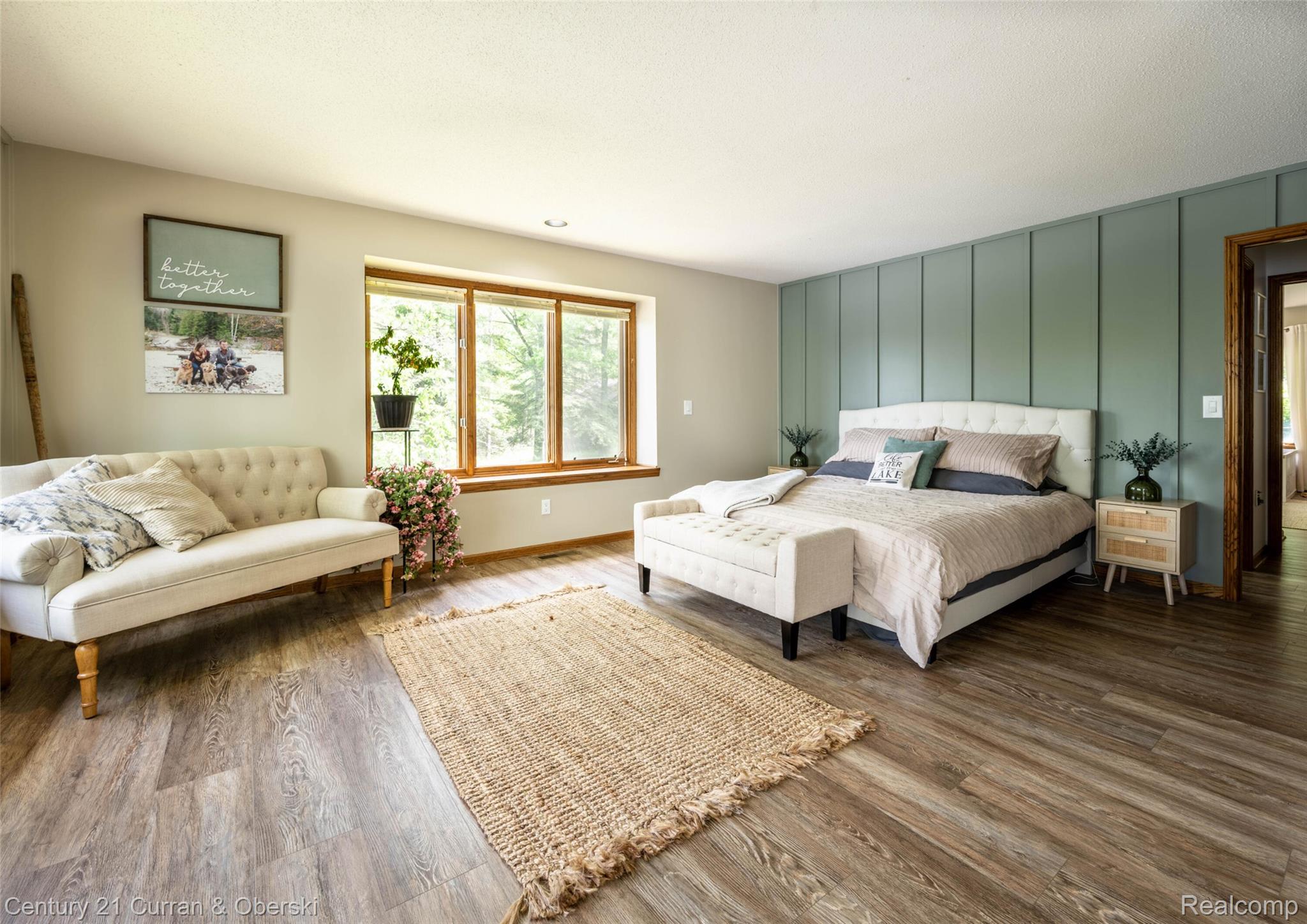 8775 Winding Rdg Drive Millersburg, MI 49759 - Photo 31 of 53 Spacious room featuring wood-finish flooring, a decorative accent wall, a large window with wood trim, and recessed lighting