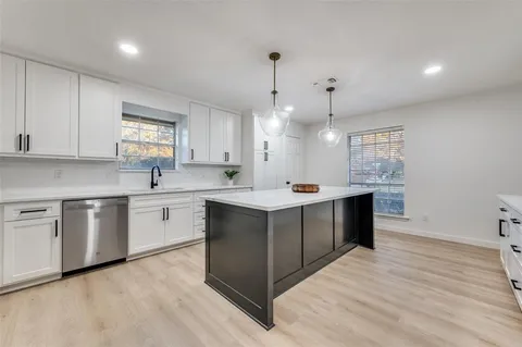 a kitchen with a sink window and cabinets