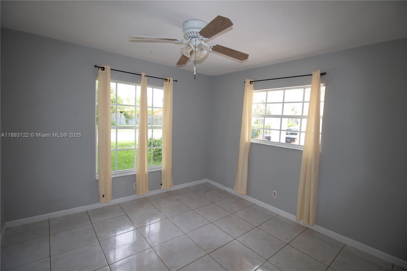 420 Southwest 62nd Avenue Margate, FL 33068 - Photo 17 of 22 an empty room with windows and chandelier fan