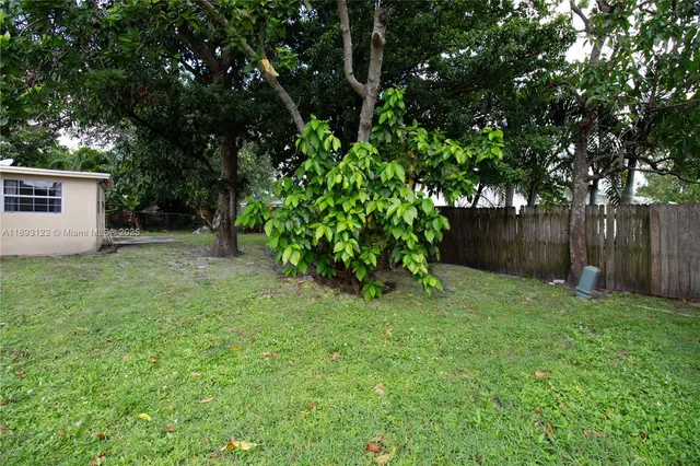 a front view of a house with a garden and trees