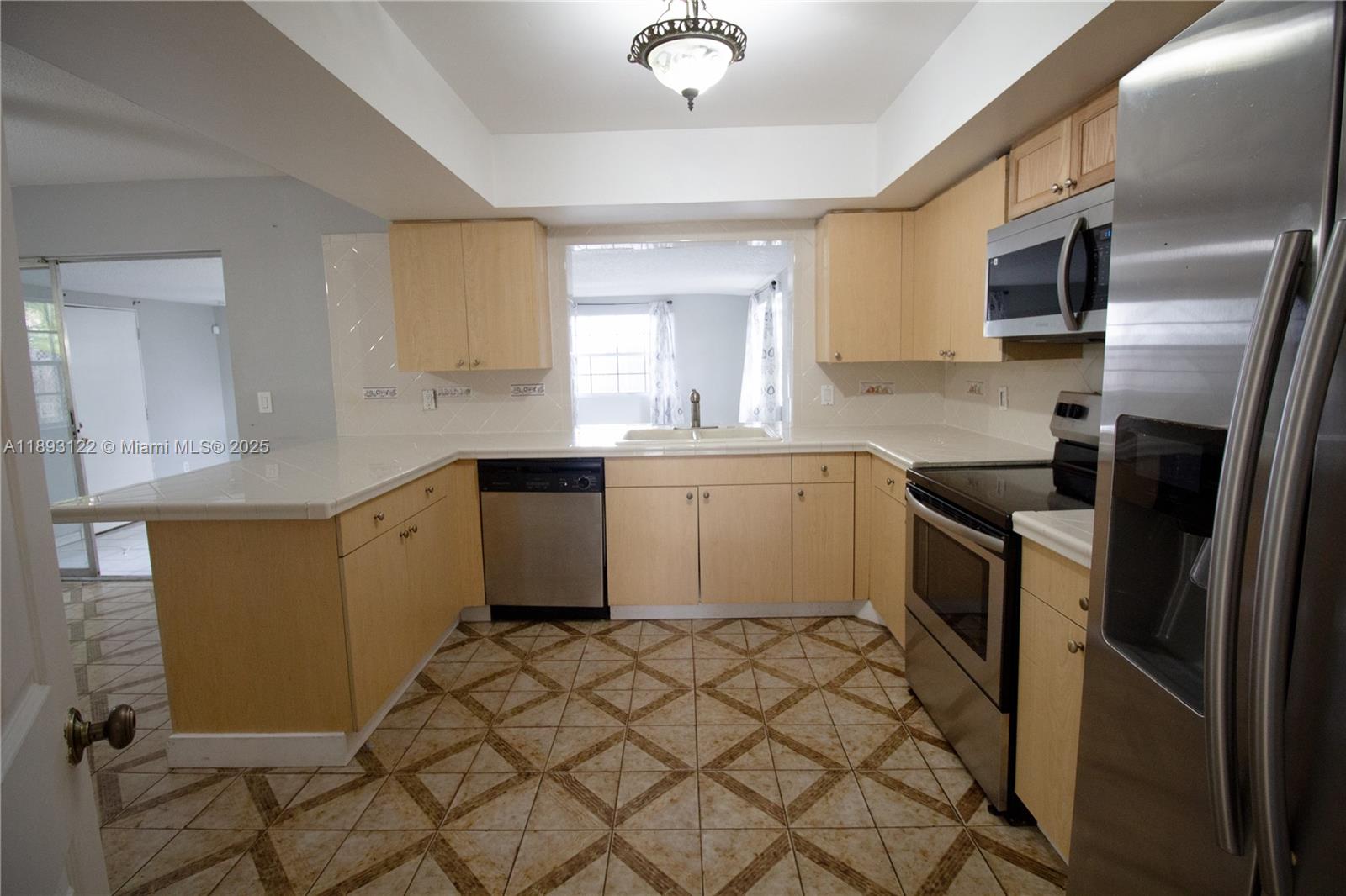 420 Southwest 62nd Avenue Margate, FL 33068 - Photo 8 of 22 a kitchen with stainless steel appliances a sink a stove a refrigerator cabinets and a window