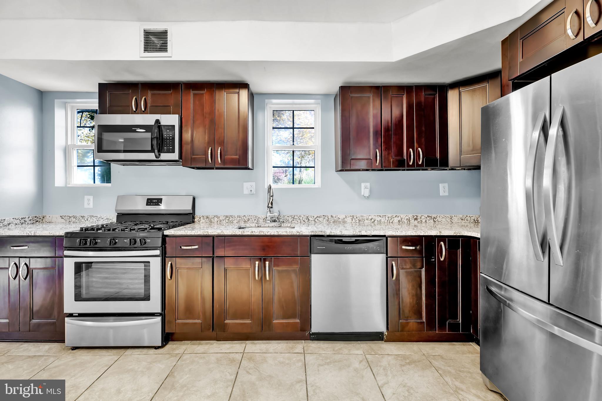 a kitchen with stainless steel appliances granite countertop a refrigerator stove and oven